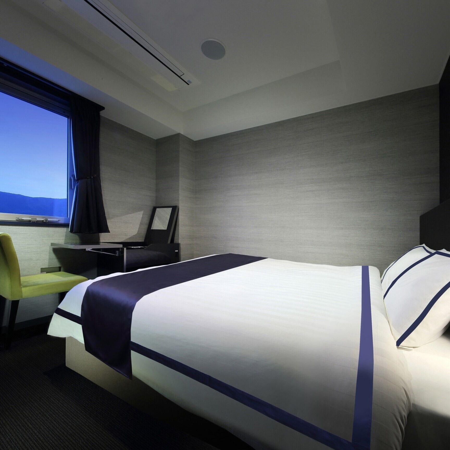 Une chambre d’hôtel avec un lit, un bureau, une chaise et une fenêtre donnant sur un paysage agréable.