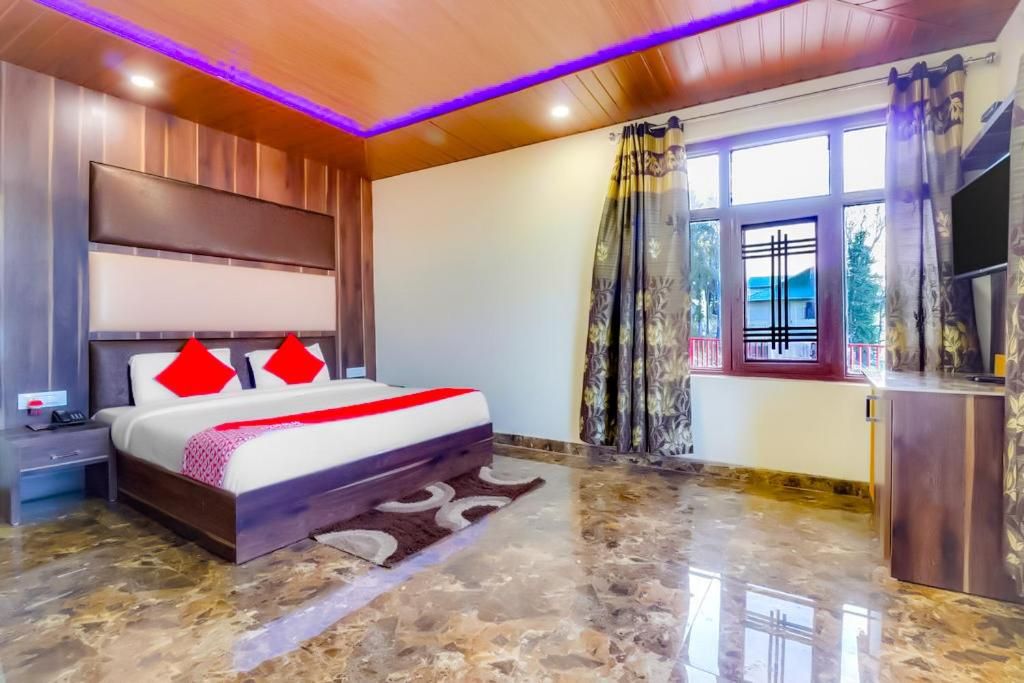 Een slaapkamer met een bed, nachtkastje en een televisie.