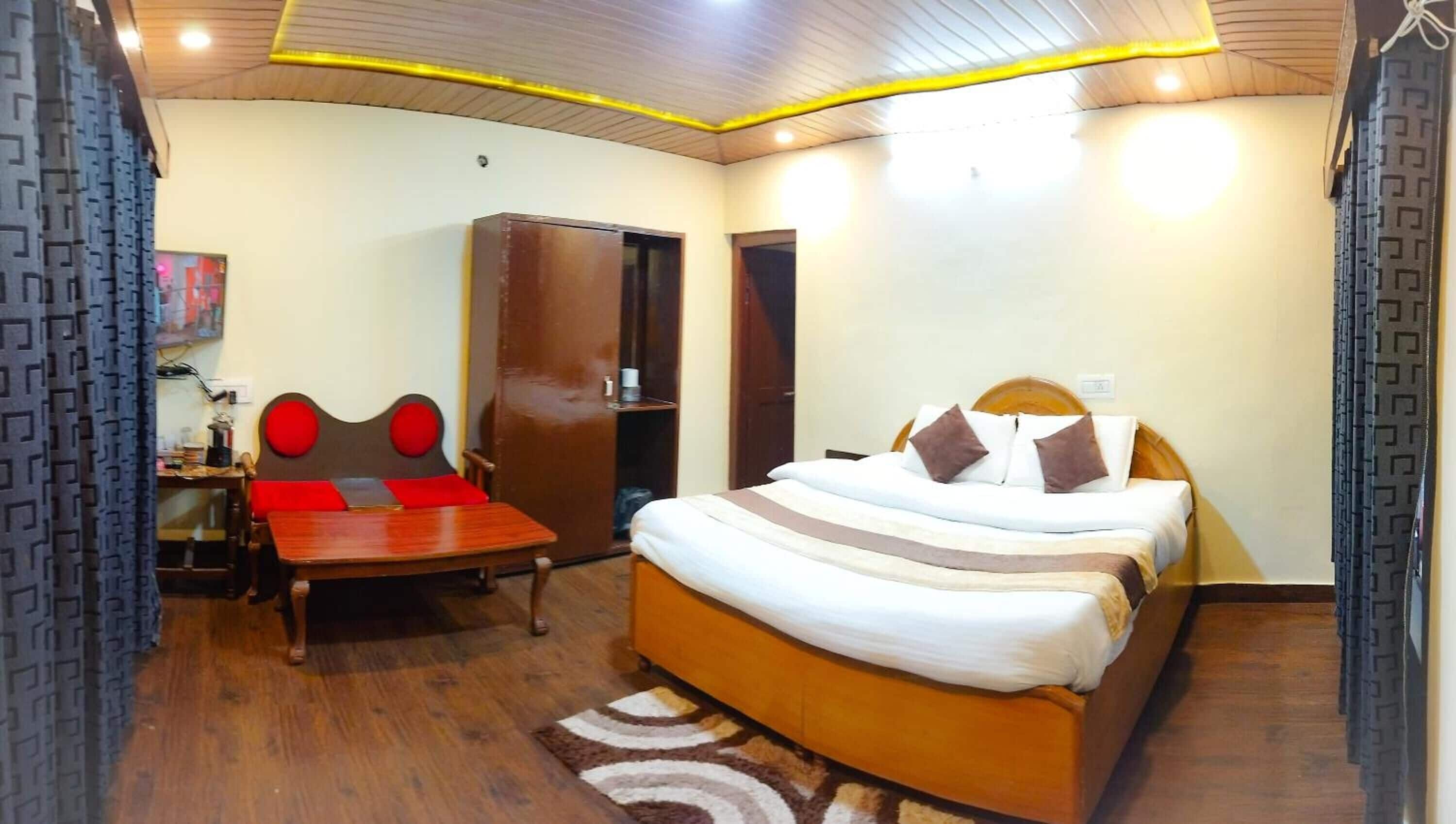 A hotel room with a bed, a desk, and a wardrobe.