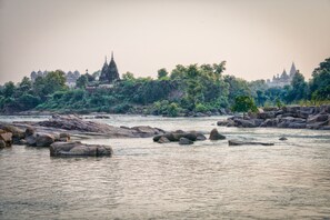 A river with rocks and a temple in the background.