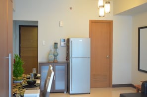 Enjoy cooking and dining in this well-equipped kitchen with a refrigerator, microwave, and dining table.
