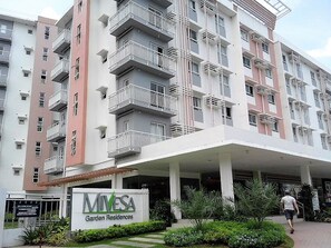 A multi-story residential building with balconies, a covered entrance, and a sign for 'MIVESA Garden Residences'. - Studio 610 (Cebu City)