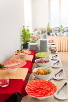 Una mesa de buffet con diversos alimentos y utensilios.