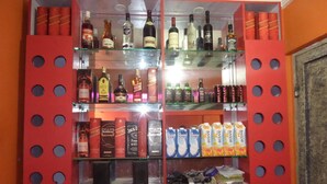 A bar area with shelves of liquor bottles, a selection of red wine, and various cans and cartons. - Time View Hotel & Suites (Lagos)
