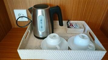 A tray with a kettle, two teapots, and a basket containing a tea set.