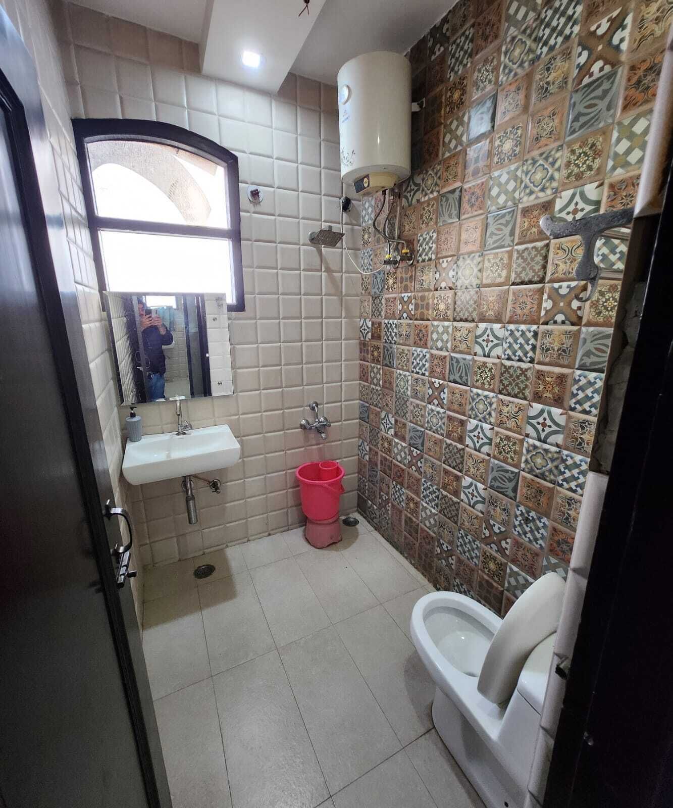 A bathroom with a white sink, a toilet, and a shower area.
