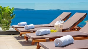 A poolside area with lounge chairs, towels, a bottle of Moët & Chandon champagne, and a glass of white wine. - Trogir Pearl Luxury Resort (Okrug)