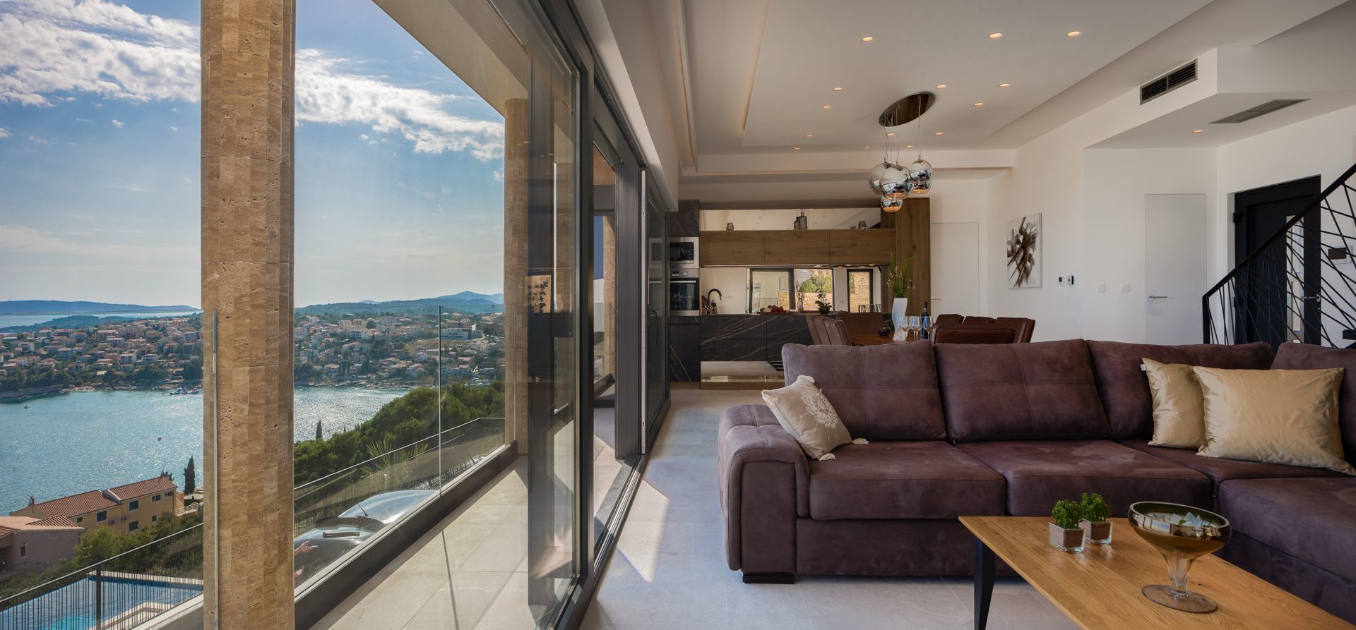 A modern living room with a large window overlooking a cityscape and water.