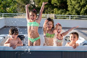 A group of children playing in a hot tub with water splashing around them. - La Terrazza di Harmakhis (Partanna)