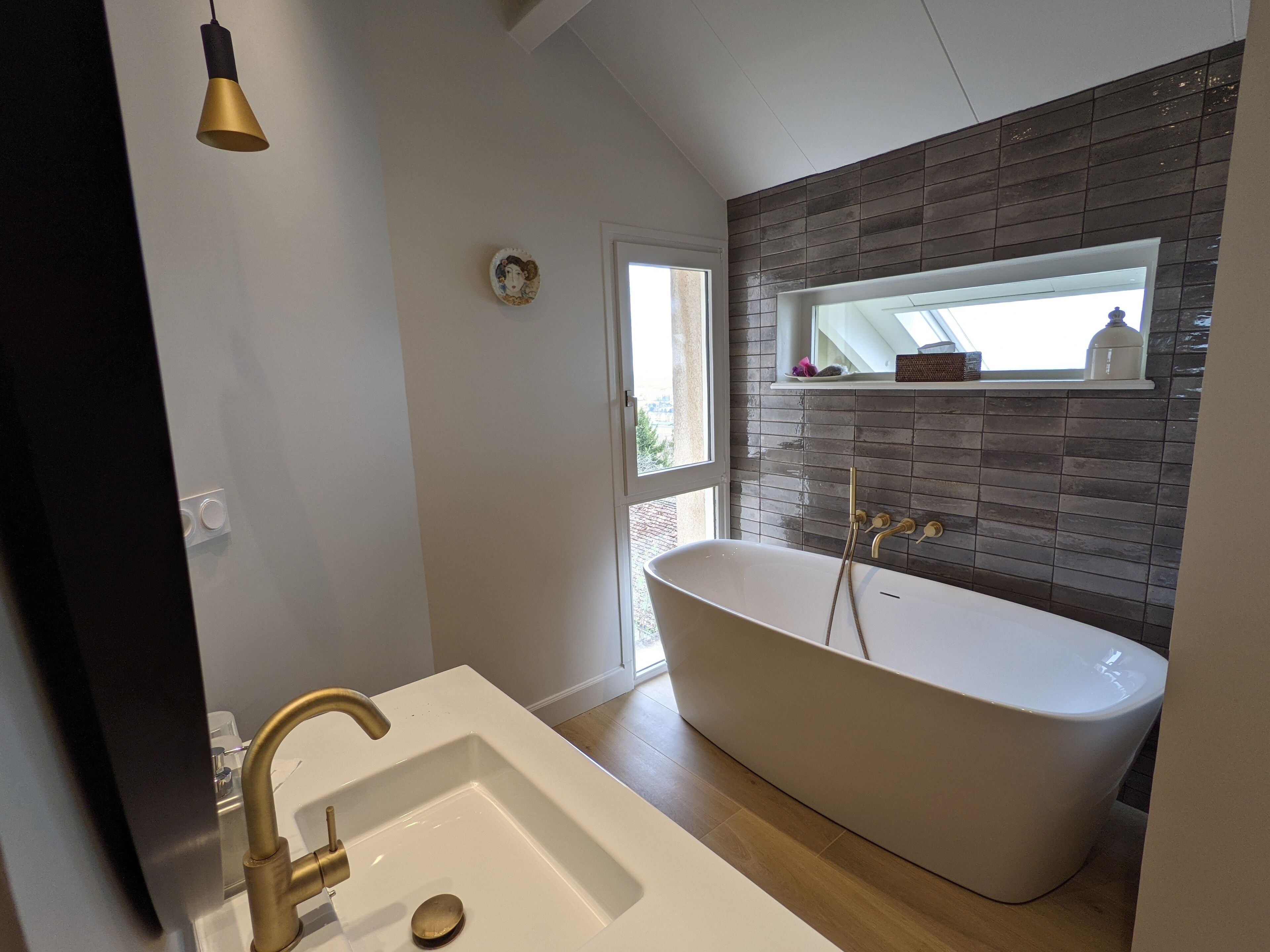 Ein modernes Badezimmer mit einer freistehenden Badewanne, einem weißen Waschbecken und einer Dusche mit Glastrennwand.