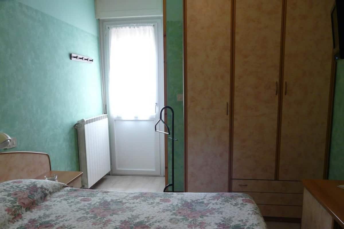 Une chambre à coucher avec un lit, une armoire et un radiateur.