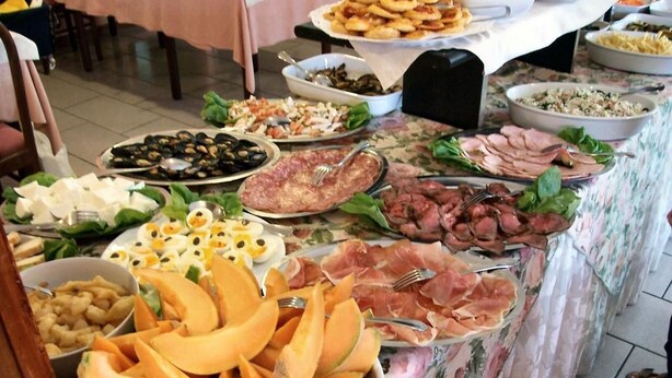 A buffet table with various food items including meats, cheeses, and fruits. - Hotel Vecchia Rimini (Comacchio)