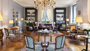 A spacious living room with a large chandelier, comfortable seating, and a view through a window. - Les Hauts de Loire (Veuzain-sur-Loire)