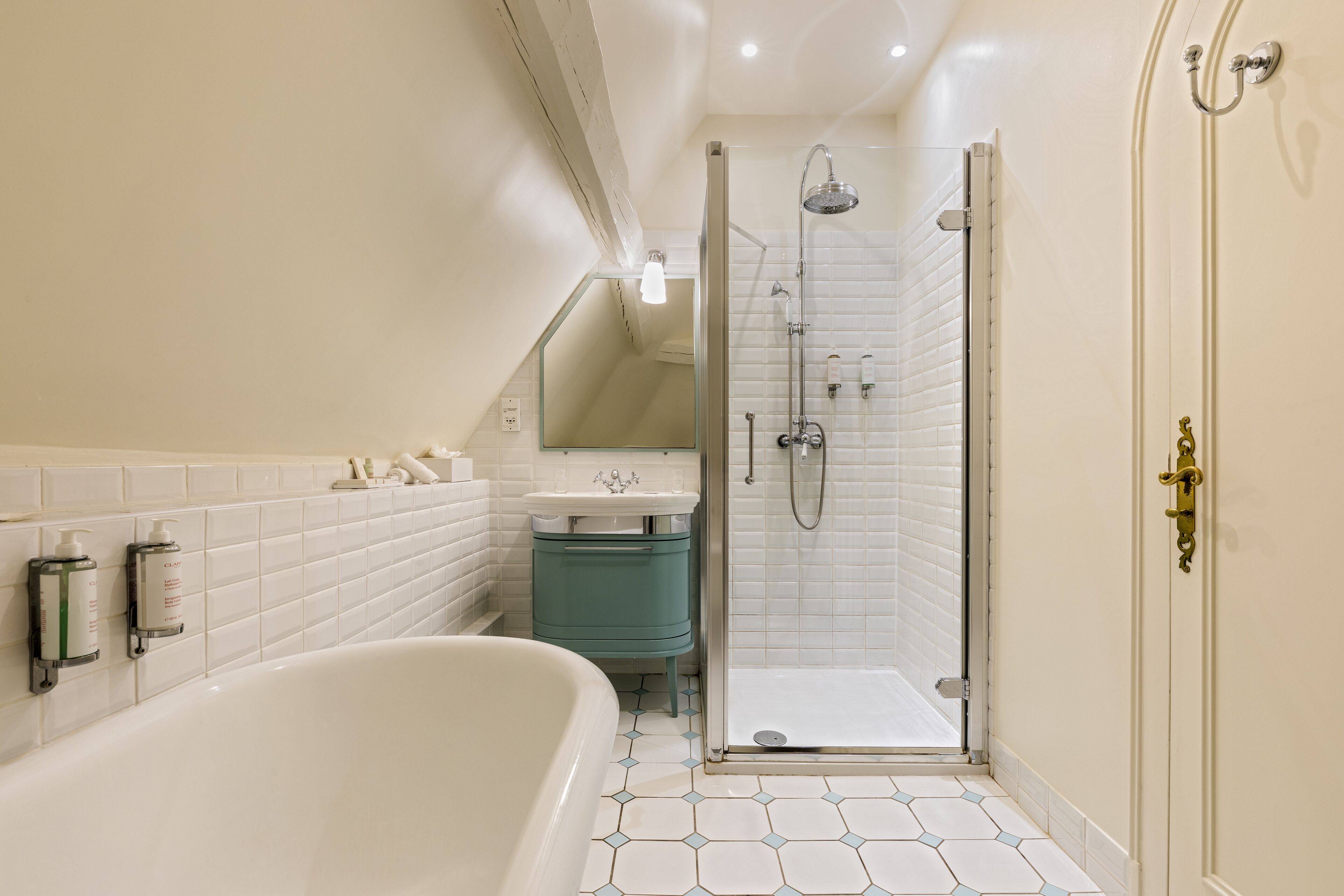 A modern bathroom with a freestanding bathtub, a glass-enclosed shower, and a vanity with a sink and mirror.
