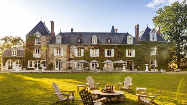 A large, historic building with a well-maintained lawn and outdoor seating area. - Les Hauts de Loire (Veuzain-sur-Loire)
