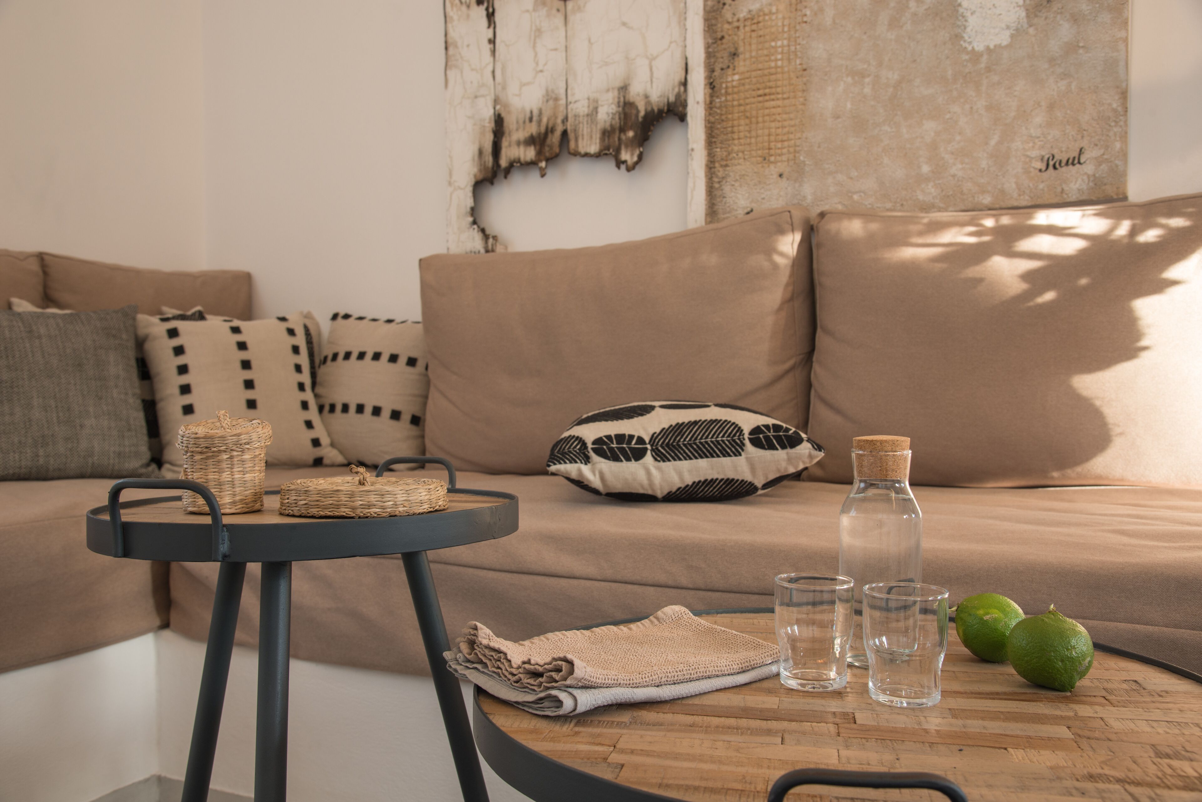 A cozy living room with a sofa, a round table, and a wall with peeling paint.