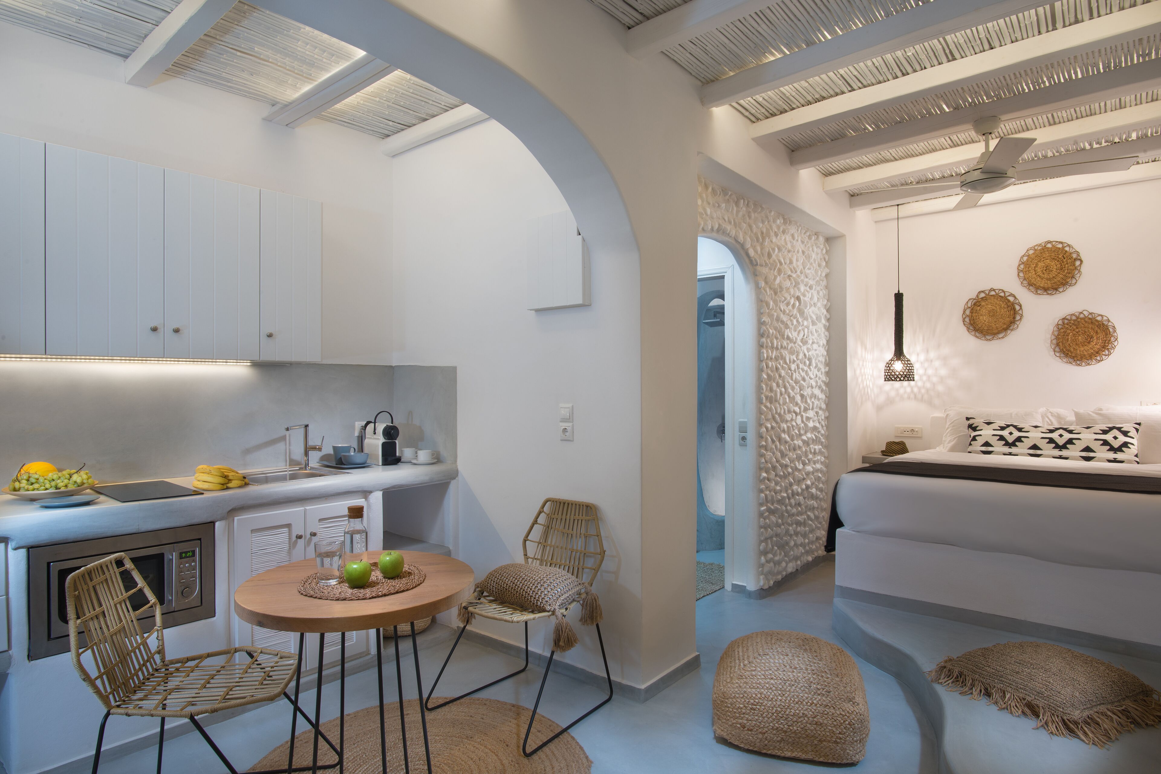 Een compacte keuken met een eethoek, met een ronde tafel, stoelen en een magnetron.