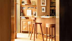 A kitchen with wooden cabinetry, a bar area, and a dining space with wooden chairs. - 9Confidentiel (Paris)