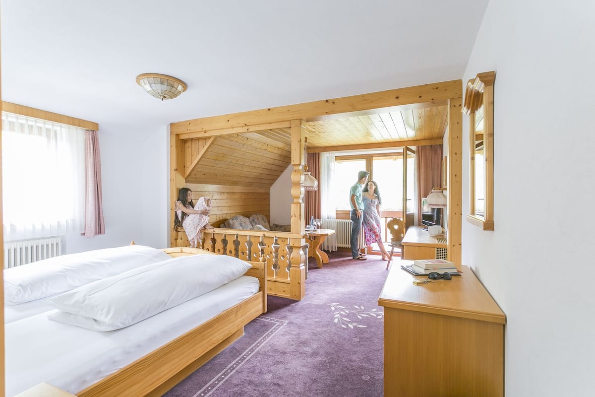 Una habitación de cabaña de madera con una cama, un escritorio y una ventana.
