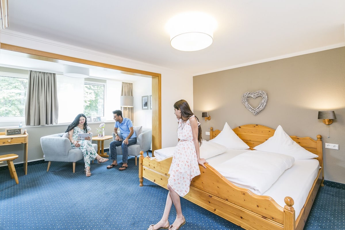 Una habitación de hotel con una cama de madera, un escritorio y una silla.