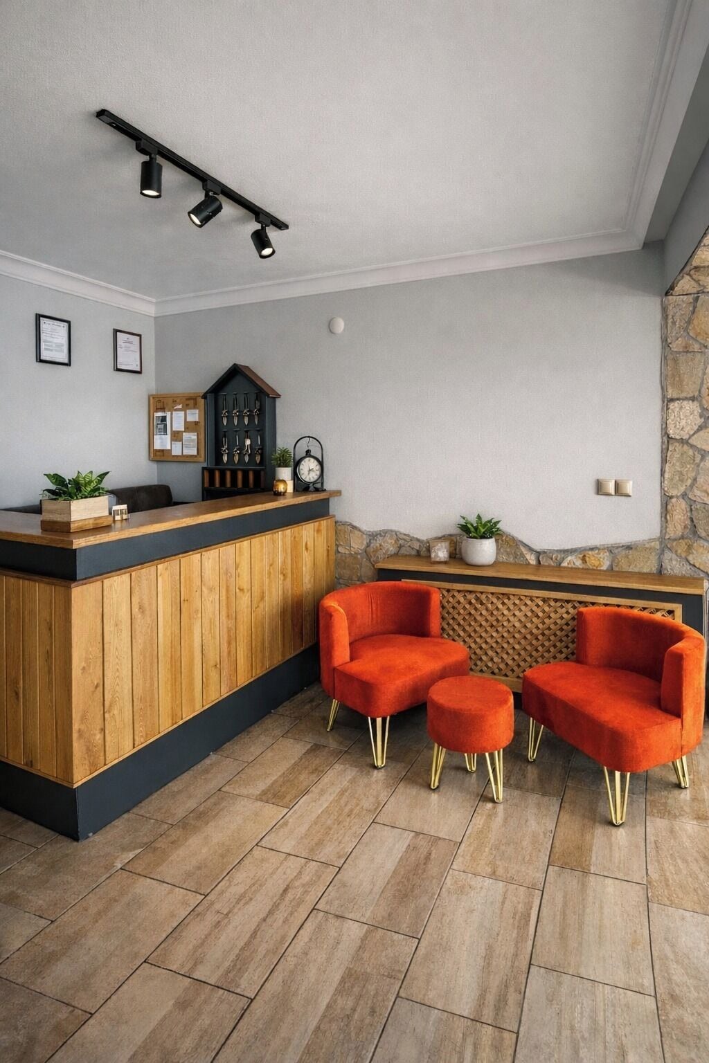 A reception area with a wooden counter, a clock, framed certificates, and a stone accent wall.