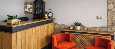 A reception area with a wooden counter, a clock, framed certificates, and a stone accent wall.