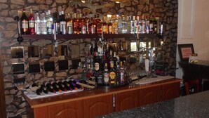 A bar area with multiple shelves of liquor bottles and a wine rack. - Pacific Hotel (Addis Ababa)