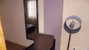 A room with a chair, a standing floor lamp, and a mirror on the wall. - Pacific Hotel (Addis Ababa)
