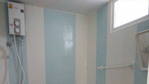 A small bathroom with a toilet, a shower, and a wall-mounted water heater. - Yamsurl House Resort (Nikhom Phatthana)