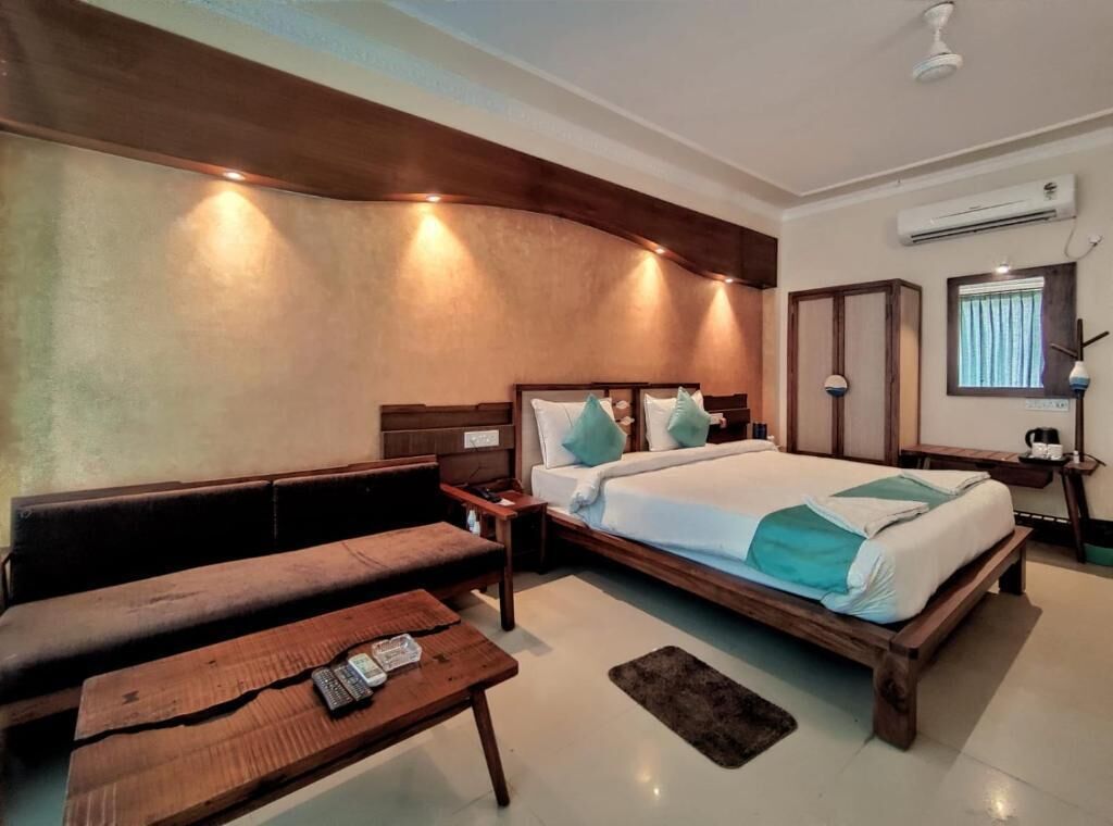 A bedroom with a bed, a bench, a bedside table, and a nightstand.