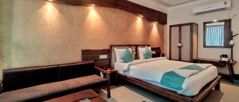 A bedroom with a bed, a bench, a bedside table, and a nightstand.