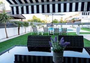 A poolside area with a covered seating area, a pool, and a view of the surrounding buildings. - Long Beach Gardens 1 (Oroklini)