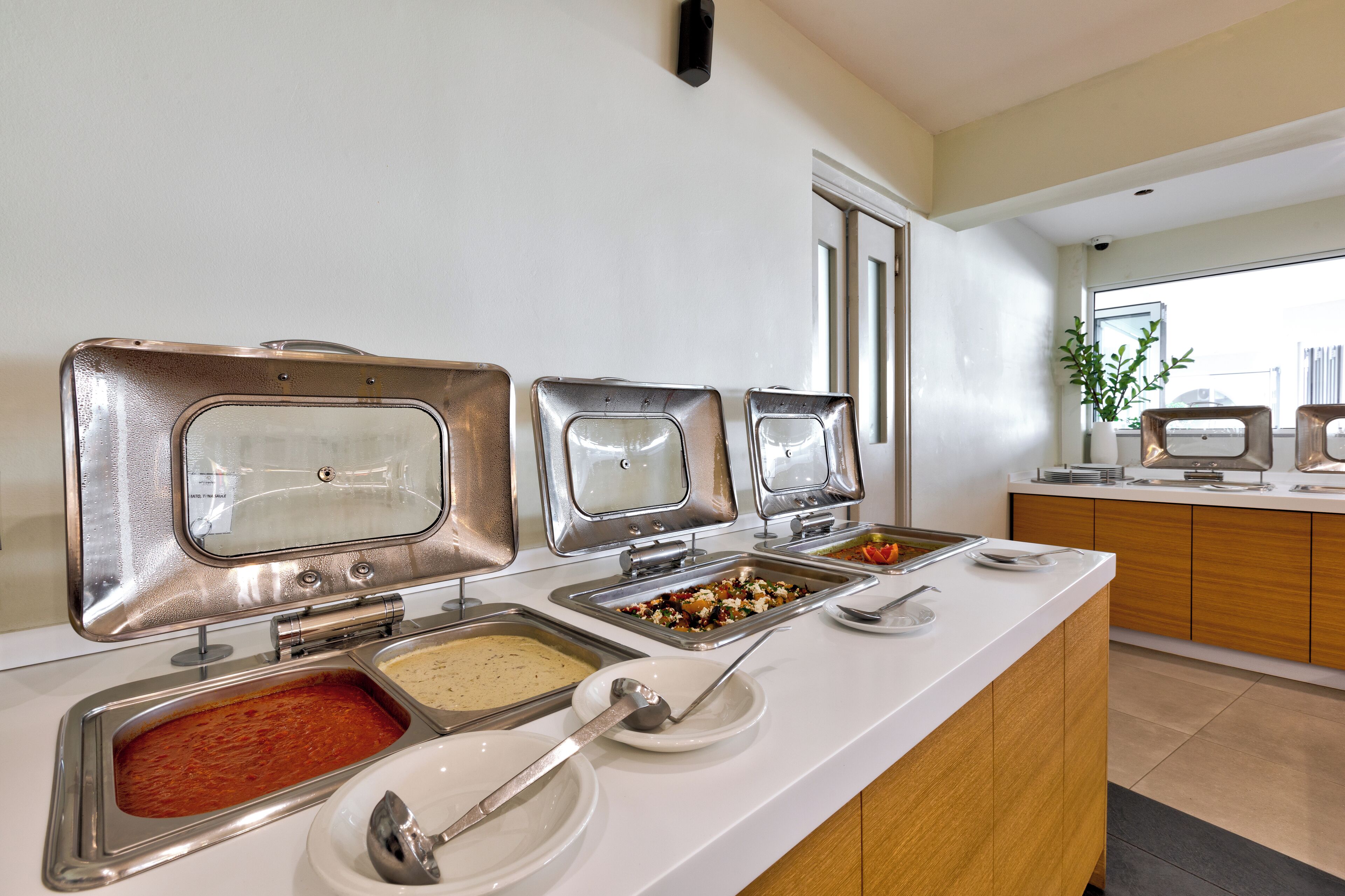 A buffet with multiple self-service stations, including various food items and condiments.