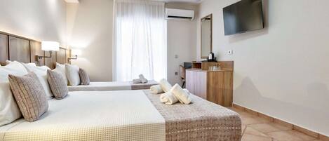 A hotel room with a large bed, a television, a desk, and a window with curtains.
