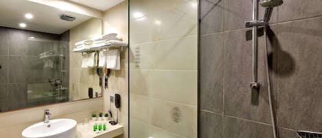 A modern bathroom with a glass shower enclosure, a sink with a mirror, and a toilet.