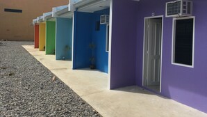 A row of colorful buildings with a gravel path in front. - Tropical Stay Accommodations (Tagbilaran)