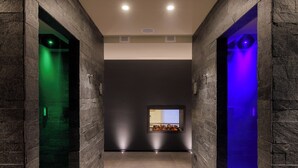 A hallway with stone walls, a recessed ceiling, and a small window with a display. - Hotel Centrale (Pejo)