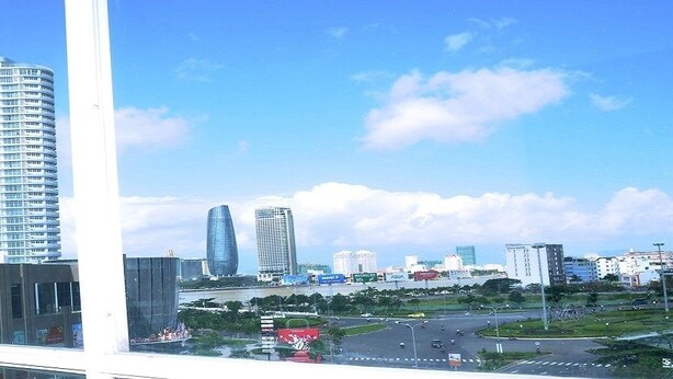 A cityscape with modern high-rise buildings and a view of a shopping area with a store named "VINCI". - A Dong Hotel (Da Nang)