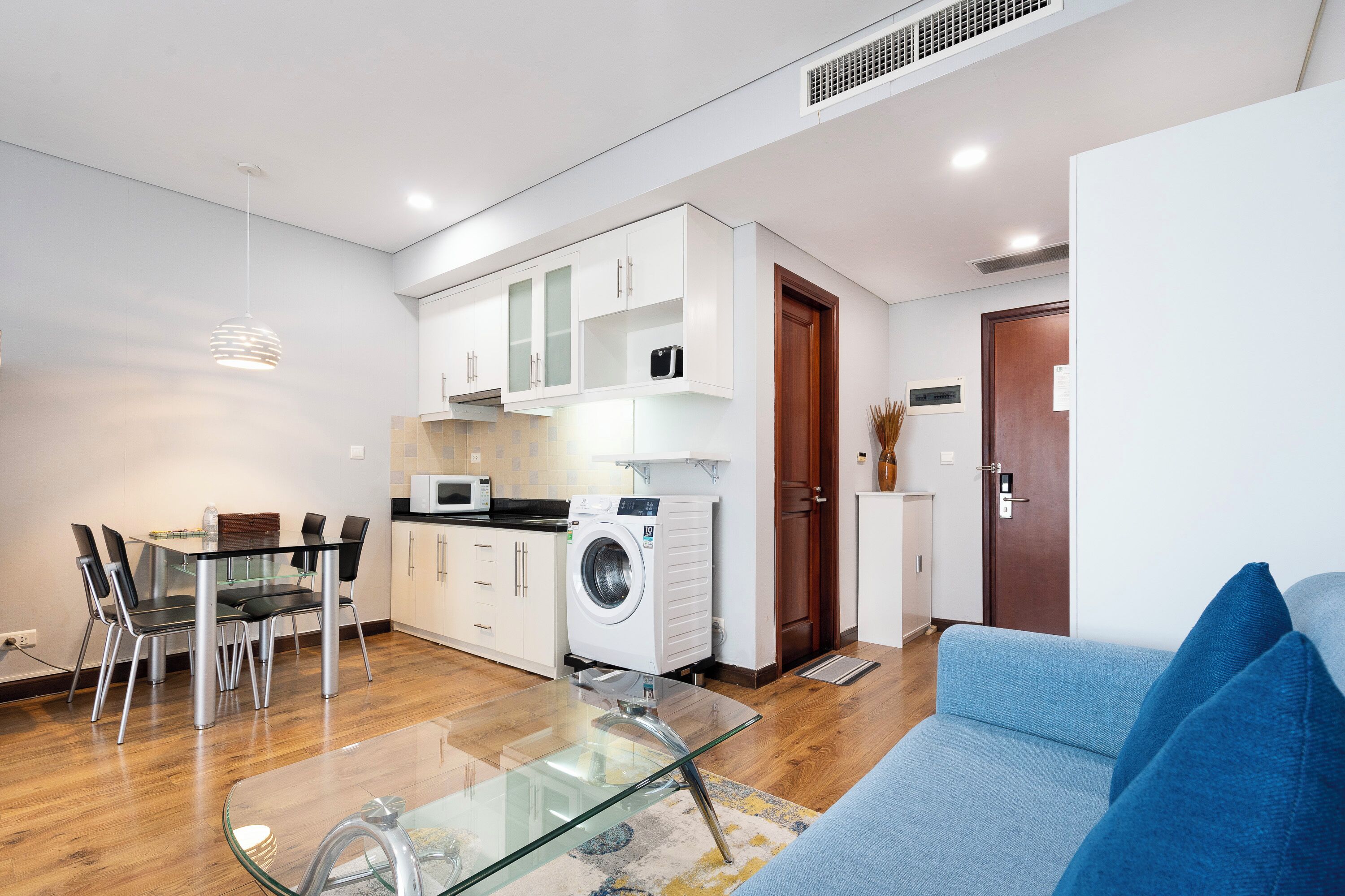 Um apartamento moderno com área de refeições, cozinha e sala de estar.