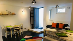 Un espacio habitable compacto con comedor, sofá, cama y ventana que proporciona luz natural.