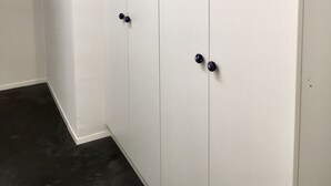 Un armario blanco con dos puertas y dos tiradores.