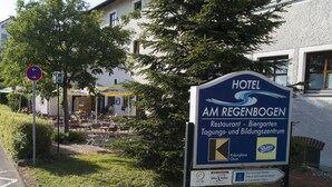 Placa do Hotel Am Reigenbogen, com restaurante, cervejaria e centro de educação juvenil.