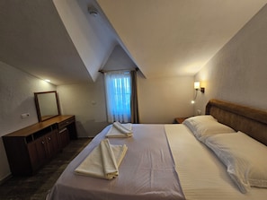 A hotel room with a bed, a desk, a mirror, a nightstand, and a window with curtains. - Dalyan Villa Kiydan Apartments (Ortaca)