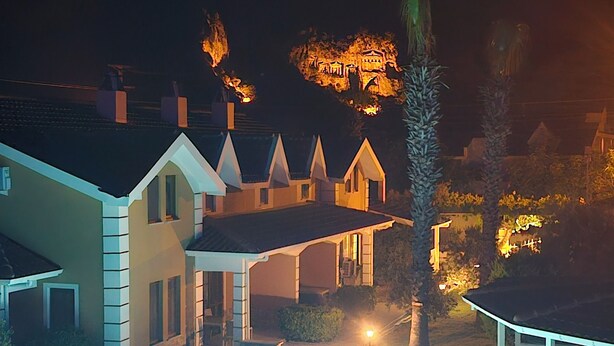 A residential property with a swimming pool, a large house with a covered patio, and a well-lit backyard. - Dalyan Villa Kiydan Apartments (Ortaca)