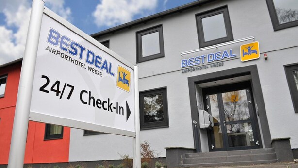 Bord van Best Deal Airport Hotel Weeze met een 24/7 check-in aanduiding.