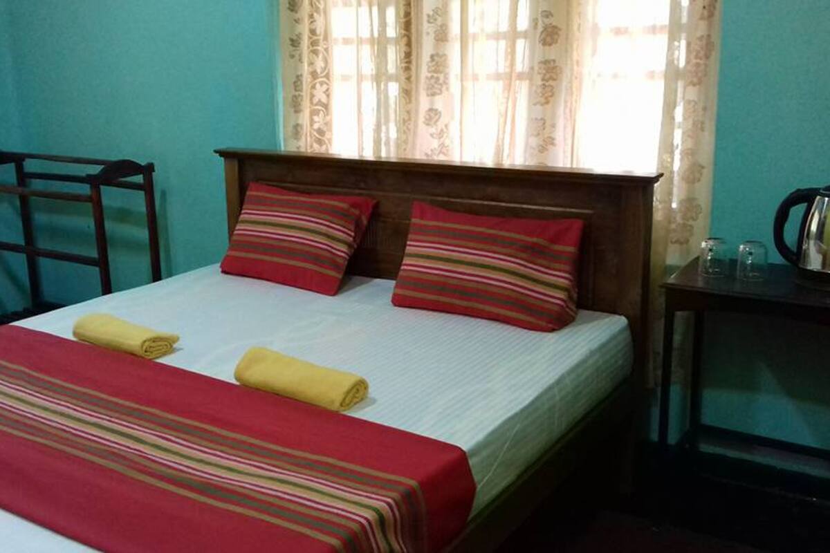 A bed with a striped blanket, two pillows, and a wooden headboard.