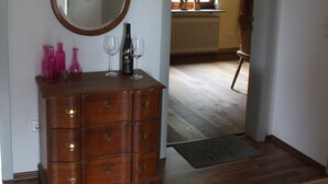 A wooden dresser with a mirror, a radiator, and a window in the background. - Ferienwohnung Bergisch Land (Wermelskirchen)