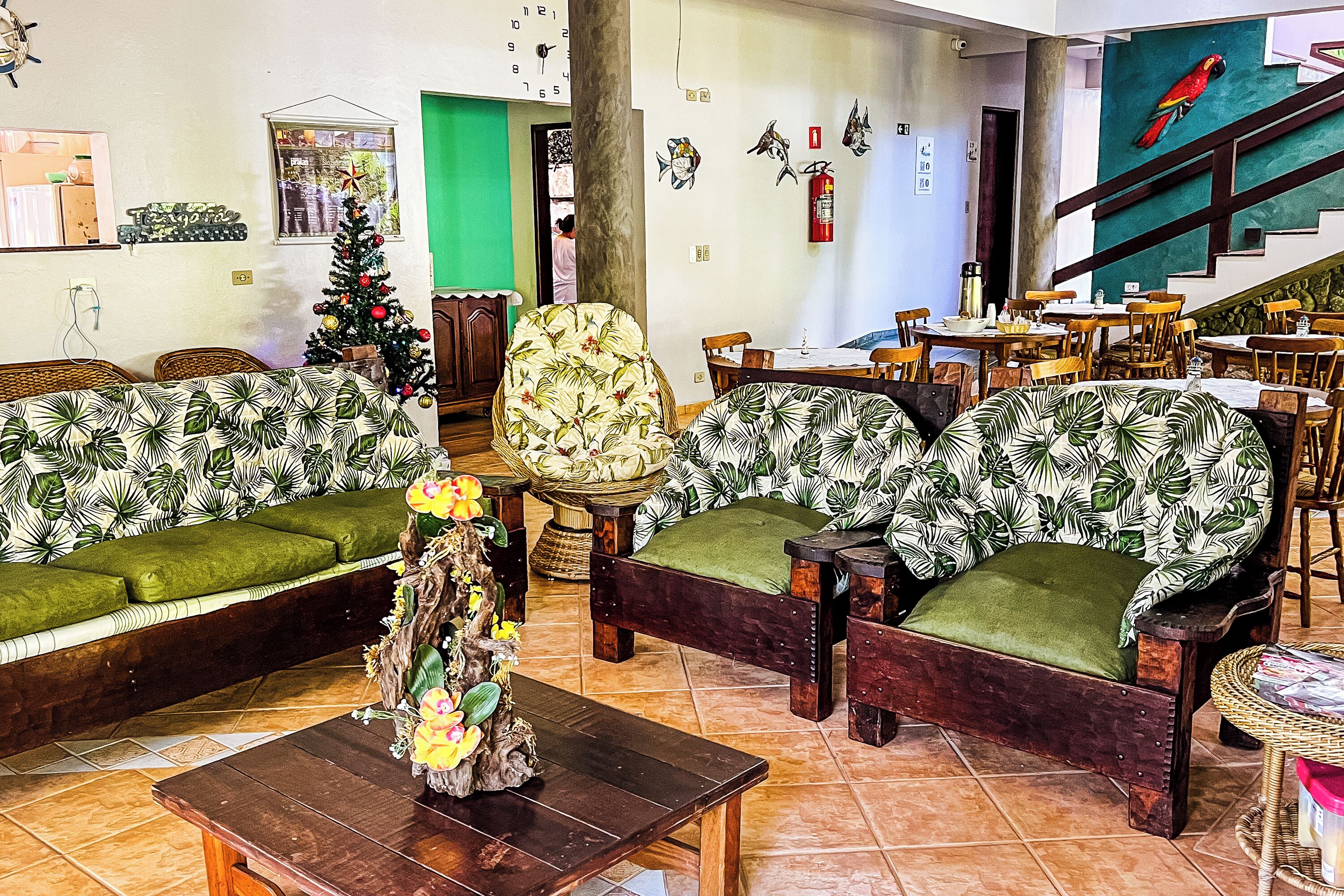 A room with a green sofa set, a wooden coffee table, and a small decorative plant.