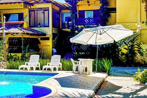 A poolside area with lounge chairs and an umbrella. - VELINN Pousada Recanto dos Tangaras (São Sebastião)