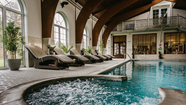 Un espace piscine avec des chaises longues et un jacuzzi.
